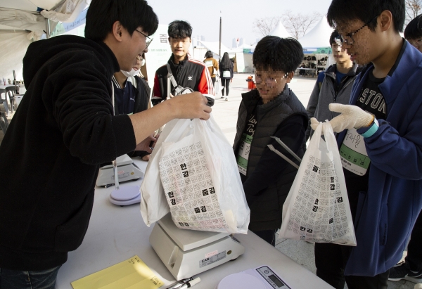 한강 줍깅 참가자들이 직접 주워온 쓰레기 무게를 측정하고 있다